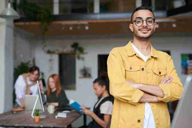 man standing in front of a table of coworkers symbolizing how to get more career money and respect