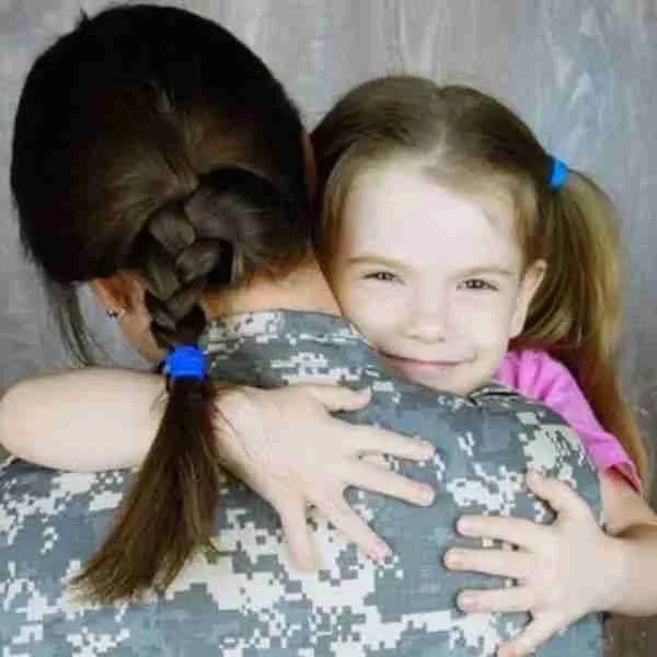 daughter hugging woman in uniform