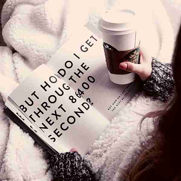 woman pondering what is self coaching while reading a book and holding coffee