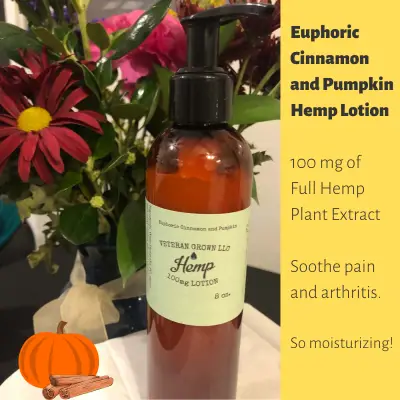 8 ounce bottle of hemp lotion next to woodland flowers